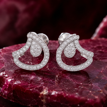 Silver-toned teardrop earrings with layered stone-set curves and suspended centre