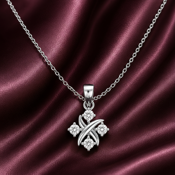 Diamond pendant necklace in white gold with four round brilliant diamonds and polished crisscross design on burgundy satin background