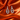 Silver pavé heart cut-out charm huggie earrings on orange satin