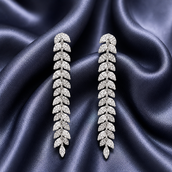 Long silver pavé leaf vine drop earrings on navy satin