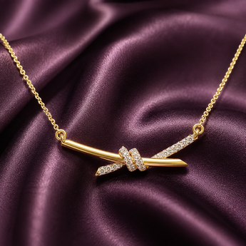 Gold-plated pavé knot bar pendant necklace on plum satin