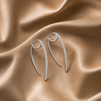Silver pavé curved spike drop earrings on beige satin