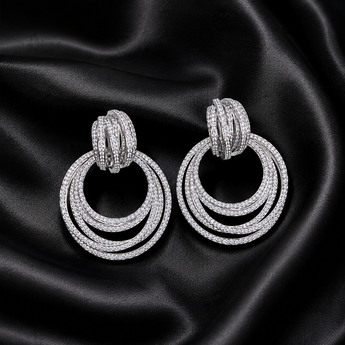 Silver pavé multi-ring statement earrings on black satin