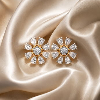Pear-cut floral stud earrings with a gold centre on cream satin