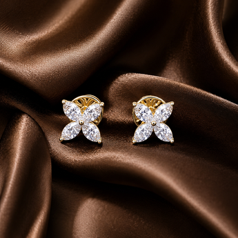 Marquise clover stud earrings with gold settings on brown satin